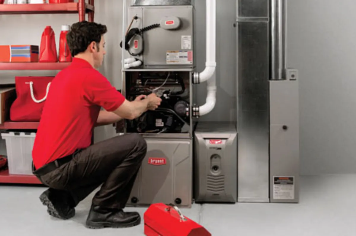 A Bryant technician at work on a furnace